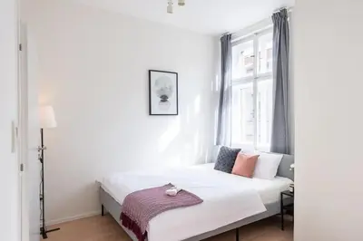 a bedroom with a white bed with a window at Vibrant Old Town Studio in Prague