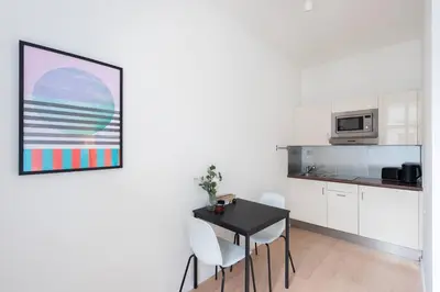 a kitchen with a table and chairs in a room at Vibrant Old Town Studio in Prague