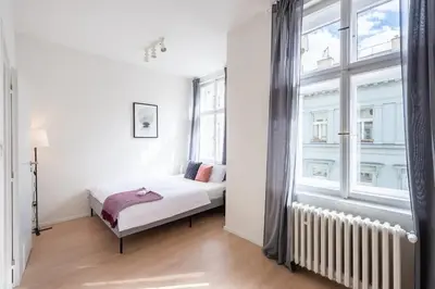 a bedroom with a bed and a large window at Vibrant Old Town Studio in Prague