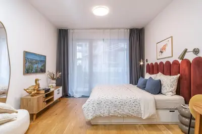 a bedroom with a large bed with a red headboard at New studio, King bed, Free parking, Terrace in Prague