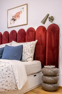 a bed with a red padded headboard in a bedroom at New studio, King bed, Free parking, Terrace in Prague