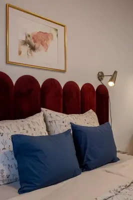 a bed with a red padded headboard and two blue pillows at New studio, King bed, Free parking, Terrace in Prague