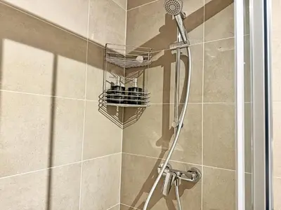 a shower with a shower head in a bathroom at New studio, King bed, Free parking, Terrace in Prague