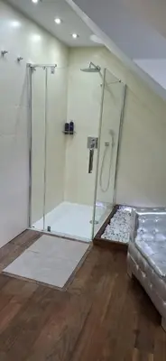 a bathroom with a shower and a bed in a room at Rodinný dům Praha 8, Kobylisy in Prague