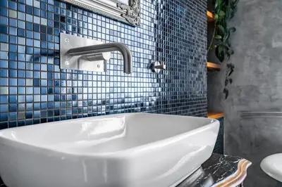 a white sink in a bathroom with blue tiles at Cozy place with wonderful view in Prague