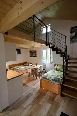 a room with a loft with a staircase and a table at Apartmány Kanoistika Roudnice in Vědomice