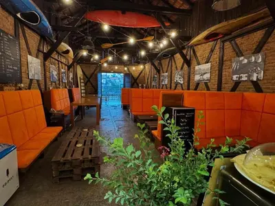 a restaurant with orange booths and tables and lights at Apartmány Kanoistika Roudnice in Vědomice