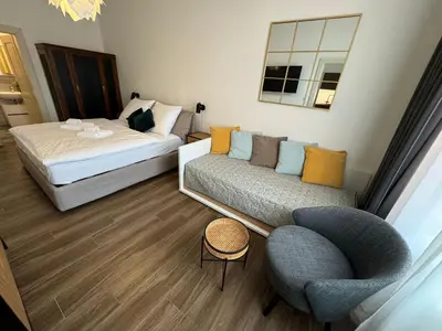 a bedroom with a bed and a couch and a chair at Quiet apartment in the city center near the metro with with balcony and parking in Prague