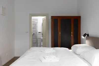 a white bed with two towels on top of it at Quiet apartment in the city center near the metro with with balcony and parking in Prague