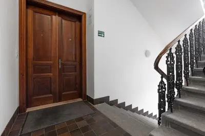 a set of stairs with a wooden door and a wooden at Quiet apartment in the city center near the metro with with balcony and parking in Prague