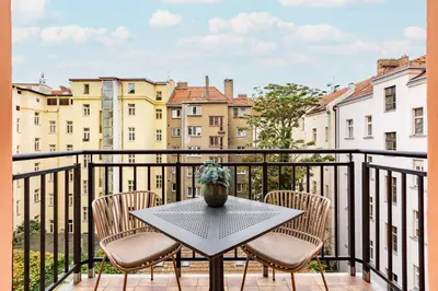 a table and chairs on a balcony with buildings at Quiet apartment in the city center near the metro with with balcony and parking in Prague