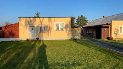 a house with a large lawn in front of it at Domek na statku in Klipec
