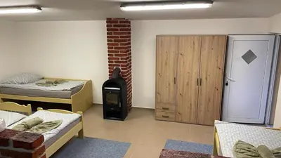 a room with two beds and a wood stove at Domek na statku in Klipec