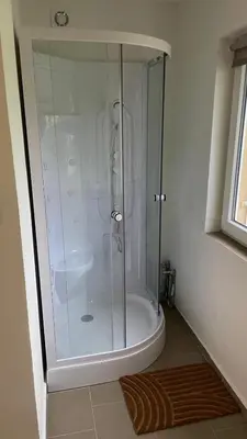 a shower with a glass door in a bathroom at Domek na statku in Klipec