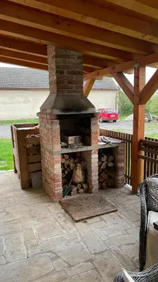 a brick pizza oven sitting on a patio at Domek na statku in Klipec