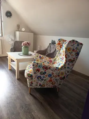 a dining room table with a white chair and a table at Magical apartment Dobříš in Dobříš