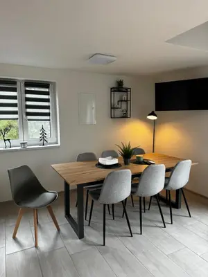 a dining room with a wooden table and chairs at Apartmán 2 Jägerhaus in Libochovice