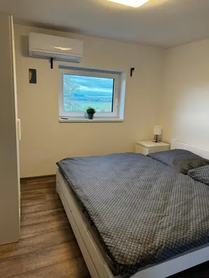 a bedroom with a bed and a window at Apartmán 2 Jägerhaus in Libochovice