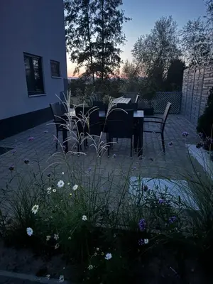 a patio with a table and chairs and flowers at Apartmán 2 Jägerhaus in Libochovice