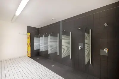 a bathroom with a row of stalls in a restroom at Hotel & Hostel Letov in Prague
