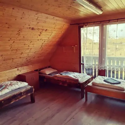 a room with two beds in a wooden house at Centrální chata Kanoistika Roudnice in Vědomice