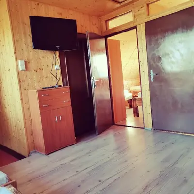 a living room with a television and a wooden floor at Centrální chata Kanoistika Roudnice in Vědomice