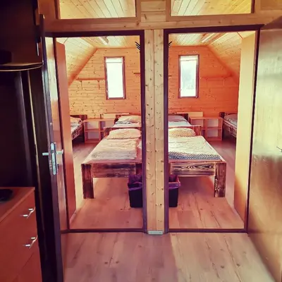 a room with two beds in a wooden house at Centrální chata Kanoistika Roudnice in Vědomice