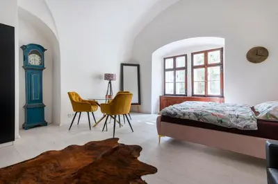 a bedroom with a bed and a table and a clock at Apartmán Hradčany 7 in Prague