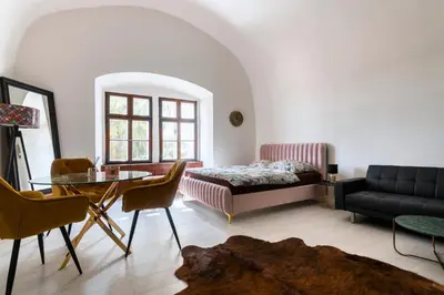 a living room with a bed and a table at Apartmán Hradčany 7 in Prague