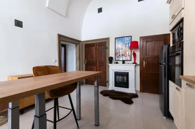 a kitchen with a table and a fireplace at Apartmán Hradčany 7 in Prague