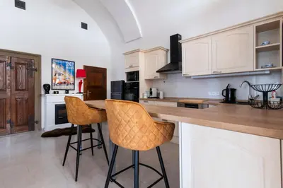 a kitchen with a counter and two bar stools at Apartmán Hradčany 7 in Prague