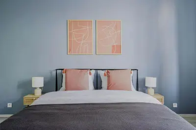 a bedroom with a bed with two tables and two lamps at Blueground Rostovska str nr park foodie area PRG-28 in Prague