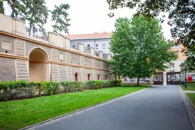 a building with a tree in the middle of a street at Blueground Rostovska str nr park foodie area PRG-28 in Prague