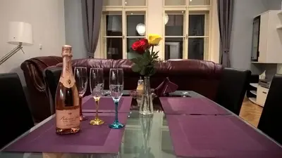 a table with a bottle of wine and glasses on it at The Old town's apartment in Prague