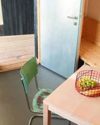 a table and a chair with a basket of grapes on it at Veritas Beyond Glamping in Hošťka