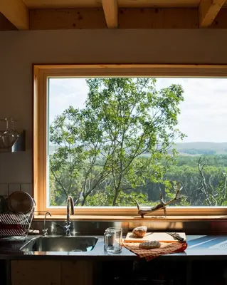 a kitchen sink and a window with a tree at Veritas Beyond Glamping in Hošťka