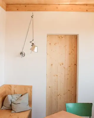 a room with a wooden door and a light fixture at Veritas Beyond Glamping in Hošťka