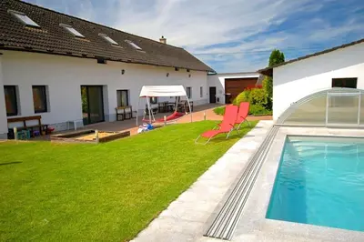 a backyard with a swimming pool and a house at Příjemné místo pro odpočinek s bazeném in Radovesice