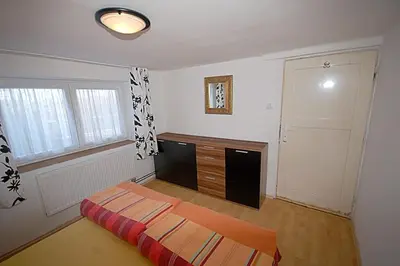 a bedroom with a bed and a dresser and a window at Příjemné místo pro odpočinek s bazeném in Radovesice