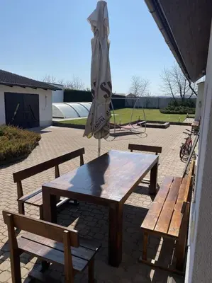 a table and benches with an umbrella on a patio at Příjemné místo pro odpočinek s bazeném in Radovesice