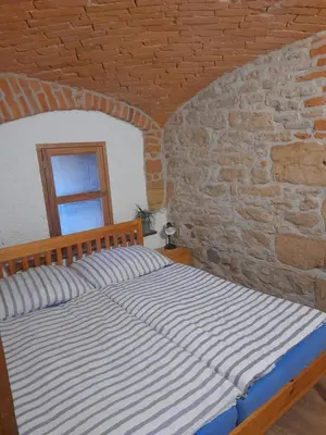 a bed in a room with a brick wall at Ubytování Ždírec - Apartmán 3 in Doksy