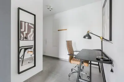 a dining room with a table and a mirror at Blueground Prague 3 new build balcony PRG-37 in Prague