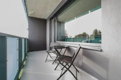 a balcony with two chairs and a window at Blueground Prague 3 new build balcony PRG-37 in Prague