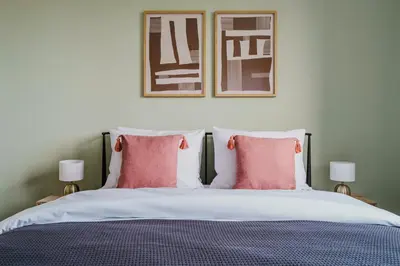 a bedroom with a bed with two pink pillows at Blueground Prague 3 new build balcony PRG-37 in Prague