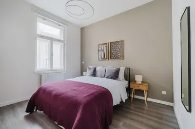 a white bedroom with a large bed and a window at Blueground Žižkov renovated nr universities PRG-35 in Prague