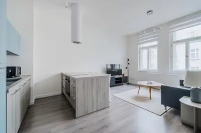 a kitchen and living room with white walls and wooden floors at Blueground Žižkov renovated nr universities PRG-35 in Prague