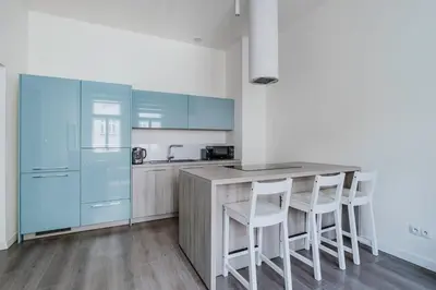 a kitchen with blue cabinets and a counter with stools at Blueground Žižkov renovated nr universities PRG-35 in Prague