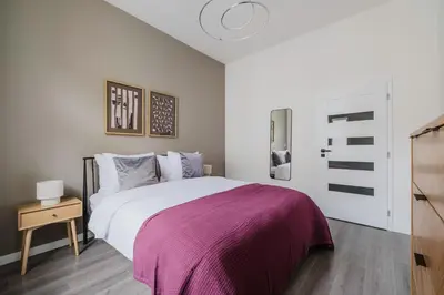 a bedroom with a large bed with a purple blanket at Blueground Žižkov renovated nr universities PRG-35 in Prague