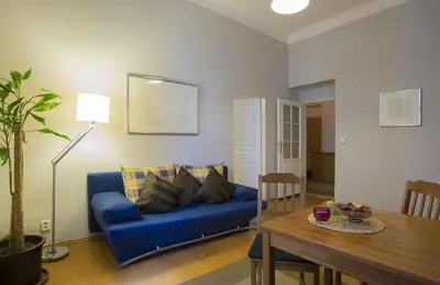a living room with a blue couch and a table at Apartment Dusni in Prague