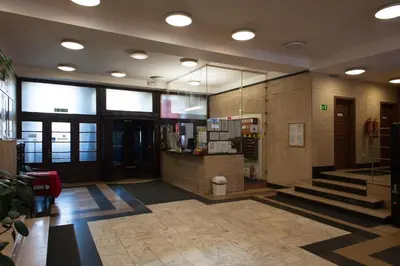 a lobby of a building with stairs and a counter at Roosevelt Hostel in Prague